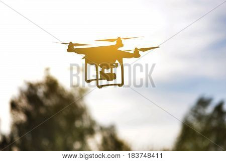 Quadrocopter flies in the air at sunset. Launching a quadrocopter in the park