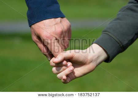 Hands. Father's and his son hands. Dad leading son over summer nature outdoor. Male and children hands closep. Family, trust, protecting, care, parenting concept.