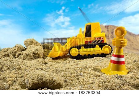 Bulldozer toy standing on a construction ground side view on a sunny day with warning sign. Background used from Pixabay under cc0 license.