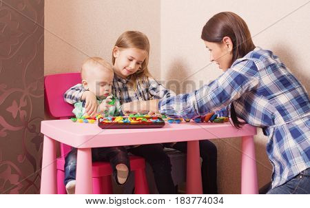 mother and children playing with toys indoor