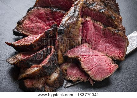 Barbecue dry aged Wagyu Bistecca alla Fiorentina as close-up on a black slate 