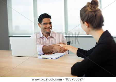 Business people shaking hands during meeting in conference room