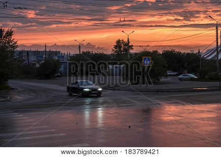 Colorful and red sunset illuminates the road in the city. Beautiful sky at sunset.