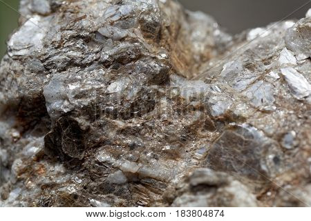 Macro photo of weathered mica minerals in coarse grained quartz rock.