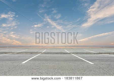 Empty parking lot on sunset sky background
