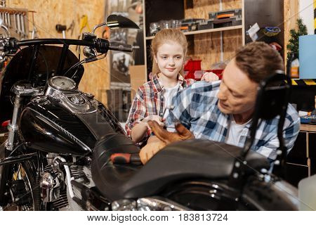 Curious little child. Charming skilled top mechanic asking for daughters help while working on his vehicle and spending time together in workshop