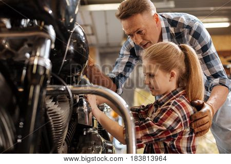 Try a little harder. Lovely positive intelligent family spending time together and fixing the bike while the dad explaining something to his daughter