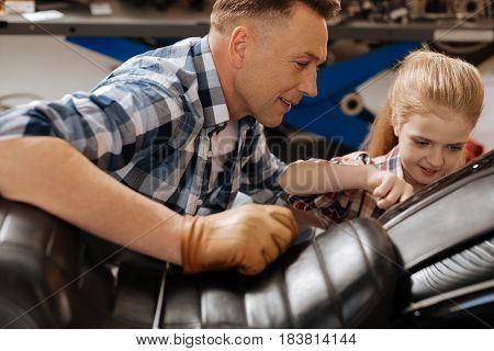 You gonna be better than me. Active strong intelligent kid tightening up the bolt while dad looking after her and teaching her some things about bikes