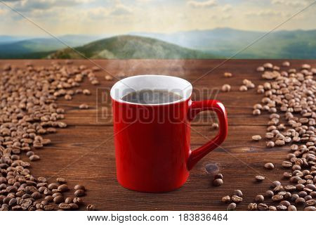 Red Cup Of Hot Coffee On A Wooden Background, On A Background Of Mountains. Smoking Coffee, Steaming