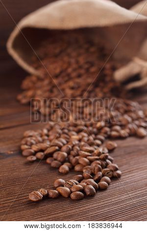 Coffee Is Poured From A Burlap On A Wooden Background