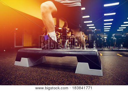 Close-up man Step for exercises in the gym with an athlete's foot.high contrast and monochrome color tone. Weight Loss. Strength of will. Psychological struggle.