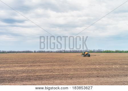 KREMENCHUK, UKRAINE - APRIL 22, 2017: Tractor preparing the field before seeding the ground. Wheat - main crops, which are grown in Ukraine