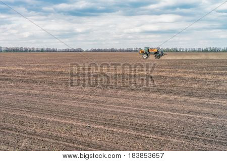 KREMENCHUK, UKRAINE - APRIL 22, 2017: Tractor preparing the field before seeding the ground. Wheat - main crops, which are grown in Ukraine