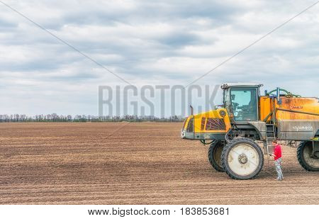 KREMENCHUK, UKRAINE - APRIL 22, 2017: Tractor preparing the field before seeding the ground. Wheat - main crops, which are grown in Ukraine