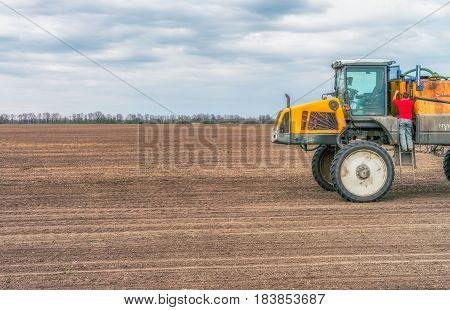 KREMENCHUK, UKRAINE - APRIL 22, 2017: Tractor preparing the field before seeding the ground. Wheat - main crops, which are grown in Ukraine
