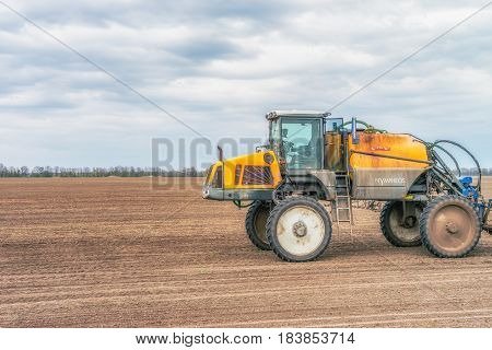 KREMENCHUK, UKRAINE - APRIL 22, 2017: Tractor preparing the field before seeding the ground. Wheat - main crops, which are grown in Ukraine