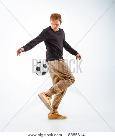 A portrait of a fan with ball on gray studio background. Freestile concept