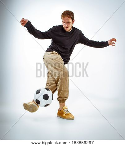 A portrait of a fan with ball on gray studio background. Freestile concept