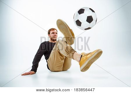 A portrait of a fan with ball on gray studio background. Freestile concept