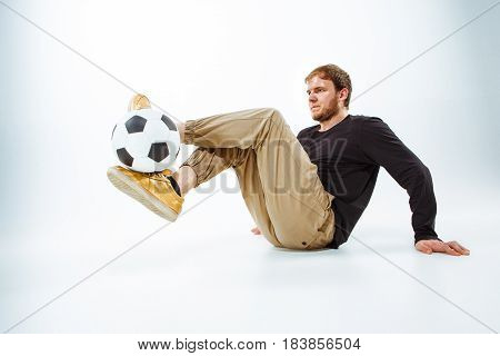 A portrait of a fan with ball on gray studio background. Freestile concept