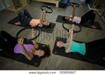 Group of fit women exercising with pilates ring in gym