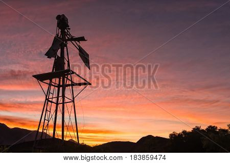 Silhouette of a broken windmill against sunset on a farm near Montagu in the Western Cape Province