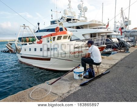 Fisherman Sitting At The Port