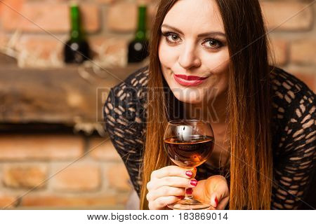 Woman Tasting Wine In Rural Cottage Interior