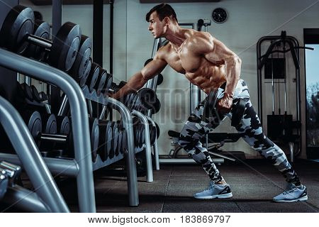 Strong muscular bodybuilder doing exercise in the gym. Part of fitness body. Sports and fitness. Fitness man in the gym. Fitness training