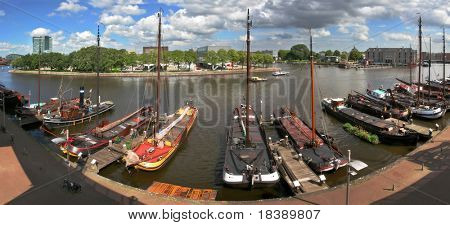Panoramaudsigt over floden Amstel og molen med skibe og både i Amsterdam, Holland.