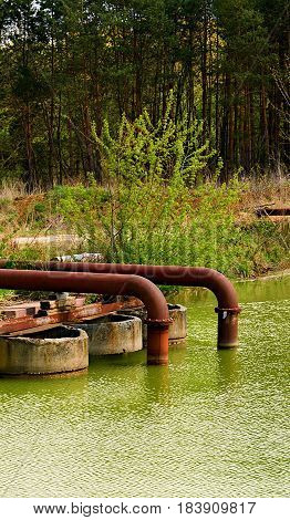 Rusty Metall Pipes Einding In The Water.