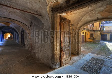 Jahrgang Tür zum kleinen Innenhof und alten Passage in Stadt Saluzzo, Norditalien.
