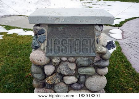 KALKASKA, MICHIGAN / UNITED STATES - NOVEMBER 27, 2016: A plaque provides informatiion on the National Trout Memorial, which stands in front of the Kalkaska Historical Museum in downtown Kalkaska.