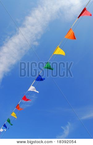 multi couleur des drapeaux du parti sur une ligne sur un fond de ciel bleu avec des nuages blancs moelleuses