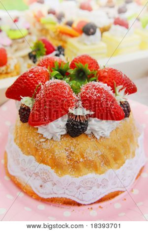 Morbido sfondo riempito con colorate torte e dolci con frutta fresca e torta di fragole