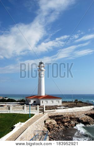 TORROX COSTA, SPAIN - OCTOBER 27, 2008 - View of the whitewashed lighthouse along the rugged coastline Torrox Costa Malaga Province Andalusia Spain Western Europe, October 27, 2008.