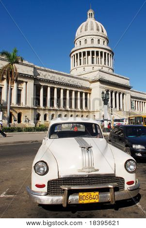 HAVANA - CIRCA DEC 2008 : Capitolio building with vintage white old american car circa December 2008 in Havana, Cuba. The Capitolio building is an exact copy of the Capitol in Washington.