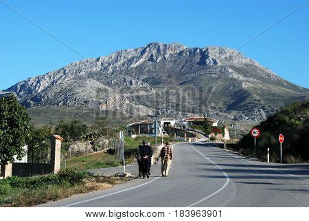 EL BURGO, SPAIN - OCTOBER 29, 2008 - Four elderly Spanish men walking along the road on the edge of the village El Burgo Malaga Province Andalusia Spain Western Europe, October 29, 2008.