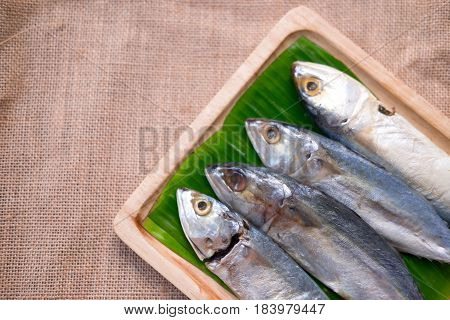 Thai raw mackerel fish on banana leaf and wooden tray
