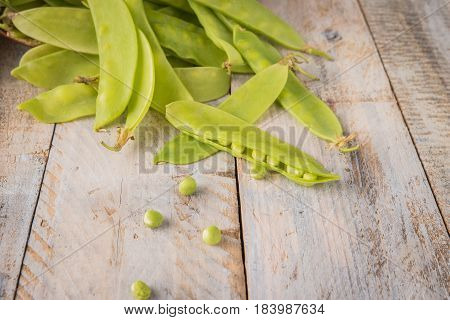 Fresh snow peas on wooden table background