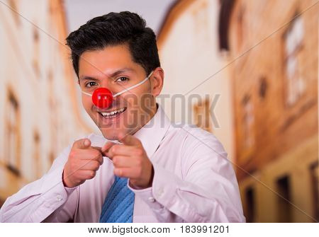 Funny handsome businessman with red plastic nose.