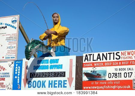 Newquay, Cornwall, Uk - April 1 2017: Figure In Yellow Souwester, And Large Fish, Advertise Fishing