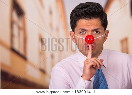 Funny handsome businessman with red plastic nose. in his face