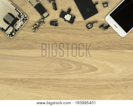 Flat Lay (Top view) of smart phone components on wooden background with copy space