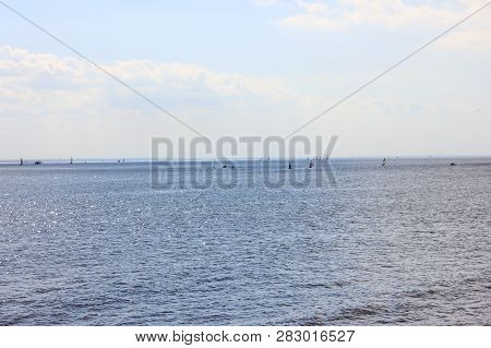 Marina Bay Water Surface On Sunny Summer Day With Blue Clear Water And Sky Background And Small Boat