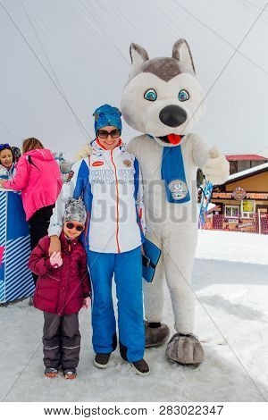Sheregesh, Kemerovo Region - April 6, 2018. U-laika Symbol Of Universiade 2019 Hugging A Little Girl
