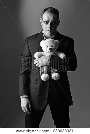 Depressed And Lonely. Mime Man Hold Teddy Bear Toy. Stage Actor With Mime Makeup In Toy Shop. Theatr