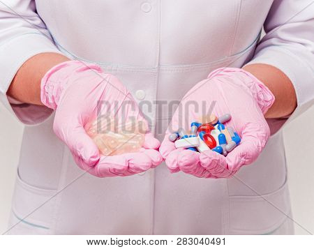 Placebo Drugs Concept. Doctor Holds Pills And Placebos. Hand In Pink Gloves With Pills. Empty Pills.