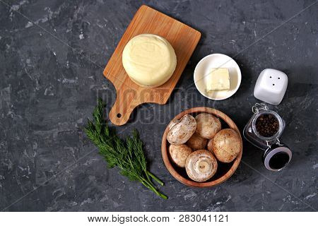 Ingredients For Cooking Baked Champignons With Suluguni On A Dark Gray Background: Raw Champignon Mu