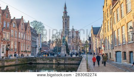 Brugge, West Flanders  Belgium - December 2018: Spiegelrei Canal, Jan Van Eyck Square And Poorterslo